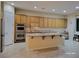 Expansive kitchen featuring oak cabinetry, stainless steel appliances, and a central island with a sink at 2764 Leys Burnett Ave, Henderson, NV 89044