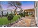 Landscaped backyard with stone patio, green lawn, and mature trees at 2785 Soft Horizon Way, Las Vegas, NV 89135