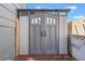 Stylish gray storage shed featuring double doors with windows for added natural light and practical outdoor storage at 308 Fox Cir, Las Vegas, NV 89107