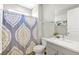 Bathroom with a shower featuring a patterned curtain, toilet, vanity, and mirror at 32 Via Del Fiume, Henderson, NV 89011