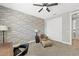 Bedroom showcases brick accent wall, ceiling fan, chair, and closet at 32 Via Del Fiume, Henderson, NV 89011