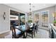 Dining room with modern chandelier, large windows, and a view of the patio at 32 Via Del Fiume, Henderson, NV 89011