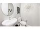 A stylish half bathroom with a modern sink, toilet, and decorative wall art at 32 Via Del Fiume, Henderson, NV 89011