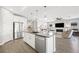 Bright, modern kitchen with white cabinets, stainless steel appliances, and a large island opening to living area at 32 Via Del Fiume, Henderson, NV 89011