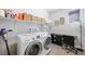 Well-lit laundry room with washer, dryer, shelving, decor, desk, and stylish flooring at 32 Via Del Fiume, Henderson, NV 89011