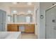 Bright bathroom with wood cabinetry, double sinks, soaking tub and a separate glass enclosed shower at 3932 Maldive Isle Ct, Las Vegas, NV 89129