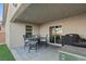 Cozy covered patio with a table, chairs, and grill, perfect for outdoor dining at 452 Triple Falls St, Indian Springs, NV 89018