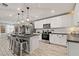 Bright, modern kitchen featuring white cabinets, stainless steel appliances, granite countertops and wood floors at 452 Triple Falls St, Indian Springs, NV 89018