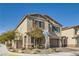 Side view of a beige two-story home featuring desert landscaping and a brick-paved driveway leading to the garage at 4813 Stony Hill St, North Las Vegas, NV 89031