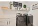 Well-organized laundry room with black washer and dryer and decorative shelving at 4813 Stony Hill St, North Las Vegas, NV 89031