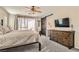 Inviting main bedroom with ceiling fan, wood dresser, and sliding barn door to the ensuite at 4813 Stony Hill St, North Las Vegas, NV 89031