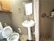 Cozy bathroom featuring a pedestal sink, a mirrored wall cabinet and neutral tile at 5255 Autumn Sky Rd, Las Vegas, NV 89118