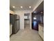 Open kitchen layout with stainless steel fridge, tiled floors and updated cabinets at 5312 W Oakey Blvd, Las Vegas, NV 89146