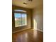 Bedroom with large window, neutral walls, and sleek, modern hardwood flooring at 5758 Yellowcrest Ct, Las Vegas, NV 89113