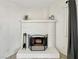 Close-up of a classic white brick fireplace with decorative accents and a protective screen at 592 Grimsby Ave, Henderson, NV 89014