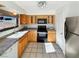 Well-lit kitchen with wood cabinets, black appliances, and a stainless steel refrigerator at 592 Grimsby Ave, Henderson, NV 89014