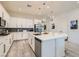 Well-lit kitchen featuring a large island, white cabinets and stainless steel appliances at 6033 Bugsy St, North Las Vegas, NV 89081