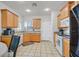 Kitchen featuring tile floors, wooden cabinetry, stainless steel appliances, and granite countertops at 6144 Corbin Ave, Las Vegas, NV 89122