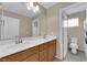 Bathroom with double sink vanity, mirror, and a toilet with a window view at 6733 Fast Brook Ct, North Las Vegas, NV 89084