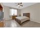 Comfortable bedroom with tile flooring, ceiling fan, and a window offering natural light, creating a cozy atmosphere at 6733 Fast Brook Ct, North Las Vegas, NV 89084