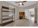 Comfortable bedroom featuring tile flooring, a ceiling fan, and a window, complemented by shelving at 6733 Fast Brook Ct, North Las Vegas, NV 89084