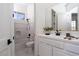 Bright bathroom features white cabinetry, tiled shower-tub, and modern black hardware at 68 Isleworth Dr, Henderson, NV 89052