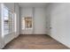 Bedroom with neutral walls, wood floors, large windows with curtains and a view of the front yard at 68 Isleworth Dr, Henderson, NV 89052