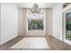 Elegant dining room with hardwood floors, a modern chandelier, and view to the garden at 68 Isleworth Dr, Henderson, NV 89052