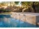 Close-up of a sparkling pool with stone water feature at 68 Isleworth Dr, Henderson, NV 89052