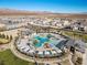 Aerial shot of a community pool surrounded by palm trees and seating areas in a Gathering friendly neighborhood at 6855 Evening Orchid St, North Las Vegas, NV 89086