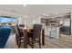 Open concept kitchen and dining area with stainless appliances, granite counters, and wood table at 6855 Evening Orchid St, North Las Vegas, NV 89086