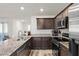 Well-equipped kitchen featuring stainless steel appliances, granite counters, and dark wood cabinetry at 6855 Evening Orchid St, North Las Vegas, NV 89086