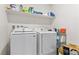 Bright laundry room featuring modern Samsung washer and dryer with shelving for storage at 6855 Evening Orchid St, North Las Vegas, NV 89086