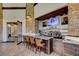 Modern bar area with stone accents, wooden beams, a granite countertop, and a wide selection of beverages at 8 Reverie Heights Ave, Henderson, NV 89011