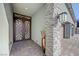 Inviting home entrance with a decorative metal front door, stone pillar, and brick walkway at 8 Reverie Heights Ave, Henderson, NV 89011