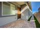 A modern home's front entrance features a brick-paved patio and walkway, enhanced by a gray accent wall and manicured artificial turf at 8 Reverie Heights Ave, Henderson, NV 89011