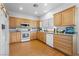 Kitchen featuring wood cabinets, white appliances, and modern countertops at 8036 Eurostar St, Las Vegas, NV 89131