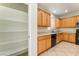 A view of the kitchen featuring wood cabinets, a pantry and tile flooring at 8045 Sundance Valley Dr, Las Vegas, NV 89178