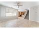 Bright living area with tile floors, ceiling fan, staircase, and open flow to the kitchen at 8045 Sundance Valley Dr, Las Vegas, NV 89178