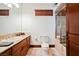 Bathroom featuring a wooden vanity, cream colored toilet and glass enclosed shower at 8280 Via Olivero Ave, Las Vegas, NV 89117