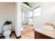 Relax in this clean bathroom, featuring a tub/shower combo, stone counters and tiled flooring at 8280 Via Olivero Ave, Las Vegas, NV 89117