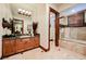 Bathroom featuring double sinks, granite countertop vanity, and shower with tile surround at 8280 Via Olivero Ave, Las Vegas, NV 89117