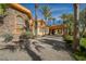 Impressive two-story home featuring stone and stucco accents, enhanced by mature palm trees at 8280 Via Olivero Ave, Las Vegas, NV 89117