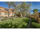 Well-manicured front yard with lush lawn and manicured bushes bordering the home's entrance at 8280 Via Olivero Ave, Las Vegas, NV 89117