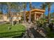 Elegant two-story home featuring a grand entrance, lush landscaping, and mature palm trees at 8280 Via Olivero Ave, Las Vegas, NV 89117