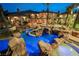 Resort-style backyard featuring a grotto-inspired pool with custom rock features and lush landscaping at 8280 Via Olivero Ave, Las Vegas, NV 89117