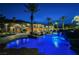 Night view of the backyard with a luxurious pool, waterfalls, palm trees, and expansive patio space at 8280 Via Olivero Ave, Las Vegas, NV 89117