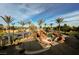 Aerial view of the custom-designed pool with rock features, lush landscape, and a tennis court in the background at 8280 Via Olivero Ave, Las Vegas, NV 89117