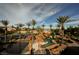 View of the custom-designed rock waterfall pool with mature landscaping and tennis court in the distance at 8280 Via Olivero Ave, Las Vegas, NV 89117