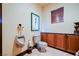 Toilet room with marble counters, wooden cabinets, and toilet at 8280 Via Olivero Ave, Las Vegas, NV 89117